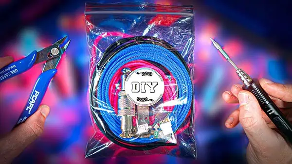 A sealed plastic bag labeled "DIY USB Cable Kit" contains cables and electronic parts, held between a pair of wire cutters and a soldering iron, set against a colorful blurred background.