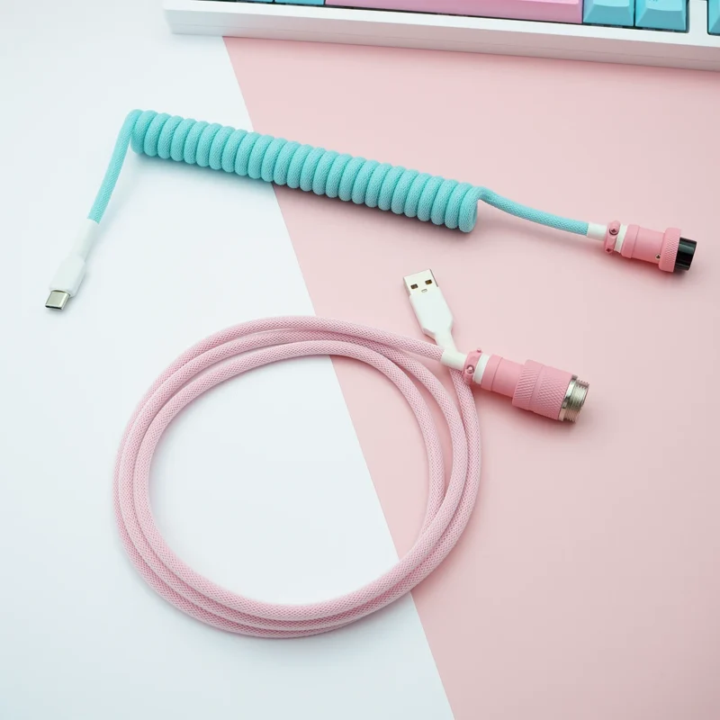 Coiled light blue and straight pink keyboard cable with USB-C and aviator connectors. Features high-quality braiding and durable heatshrink for longevity.