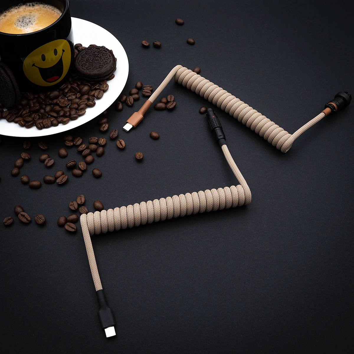 Coiled beige keyboard cable with USB-C and detachable aviator connectors, featuring a durable braiding and a sleek finish, ideal for custom setups.