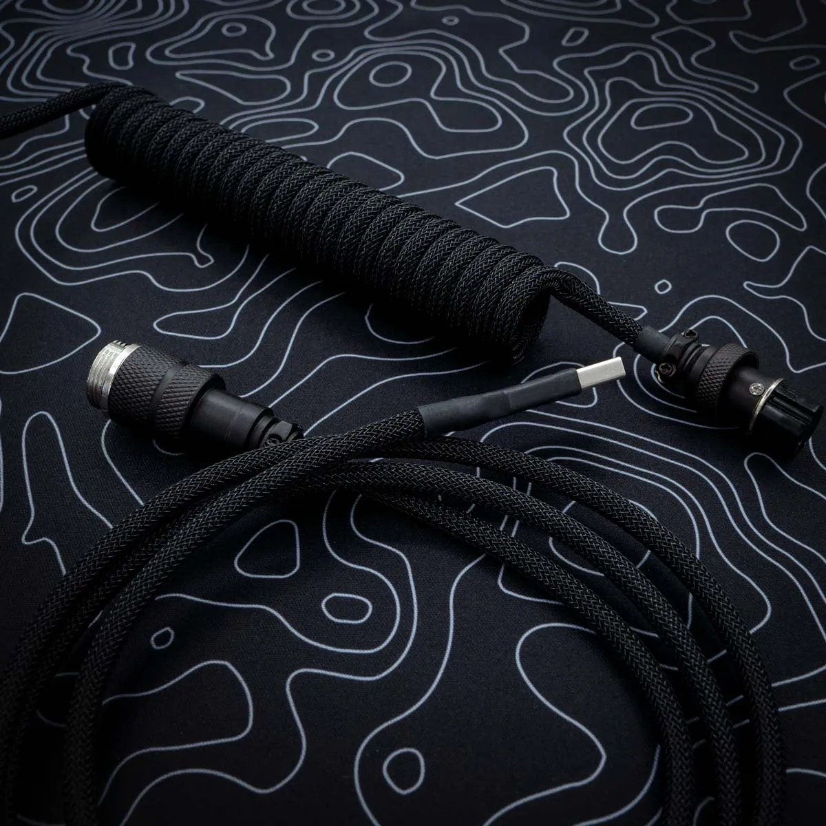 Custom black keyboard cable featuring a coil section, USB connectors, and high-quality paracord braiding. Ideal for enhancing your setup.