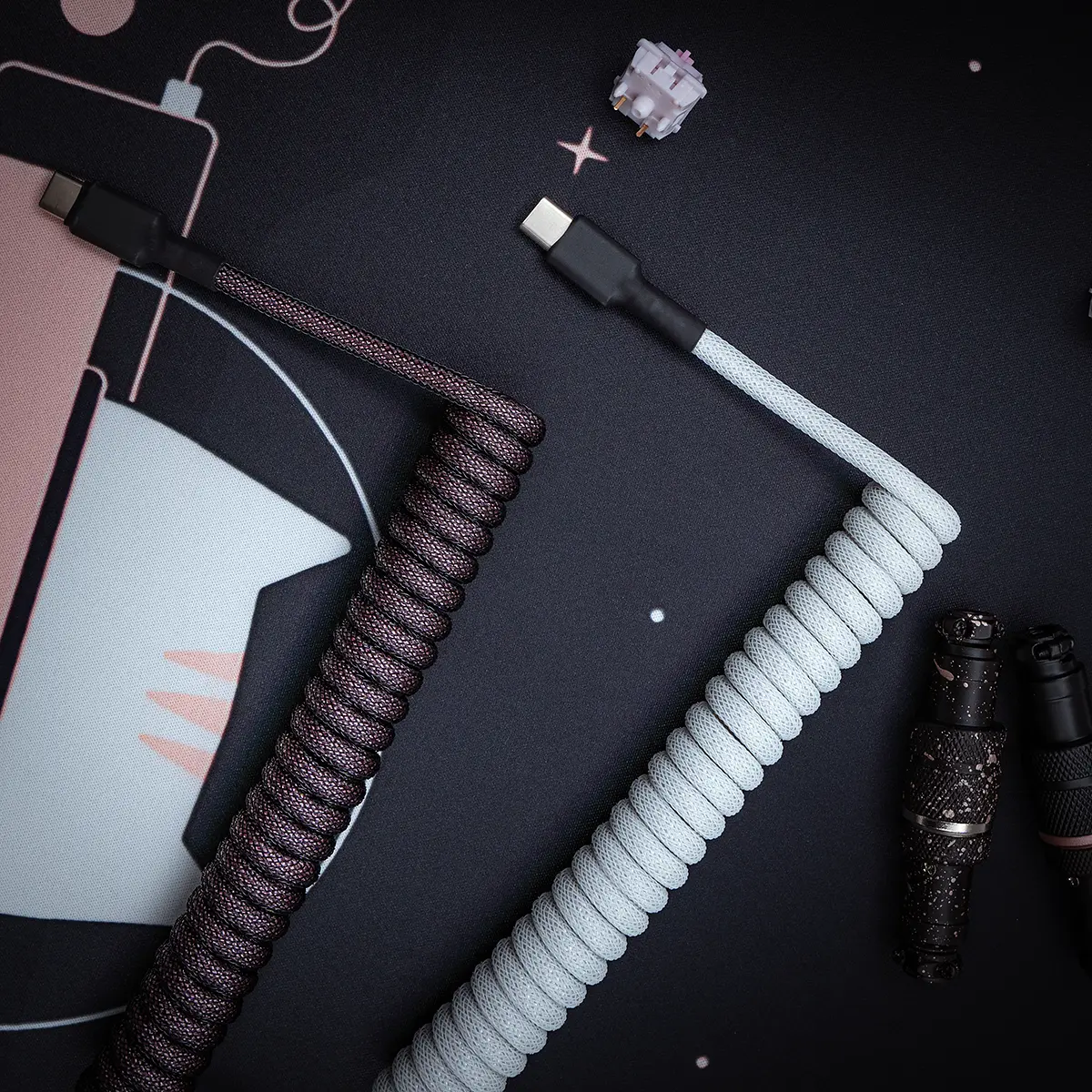 Stylish GMK Olivia keyboard cable featuring a coiled design in dark and light colors, USB-C connectors, premium paracord finish, and durable heatshrink.