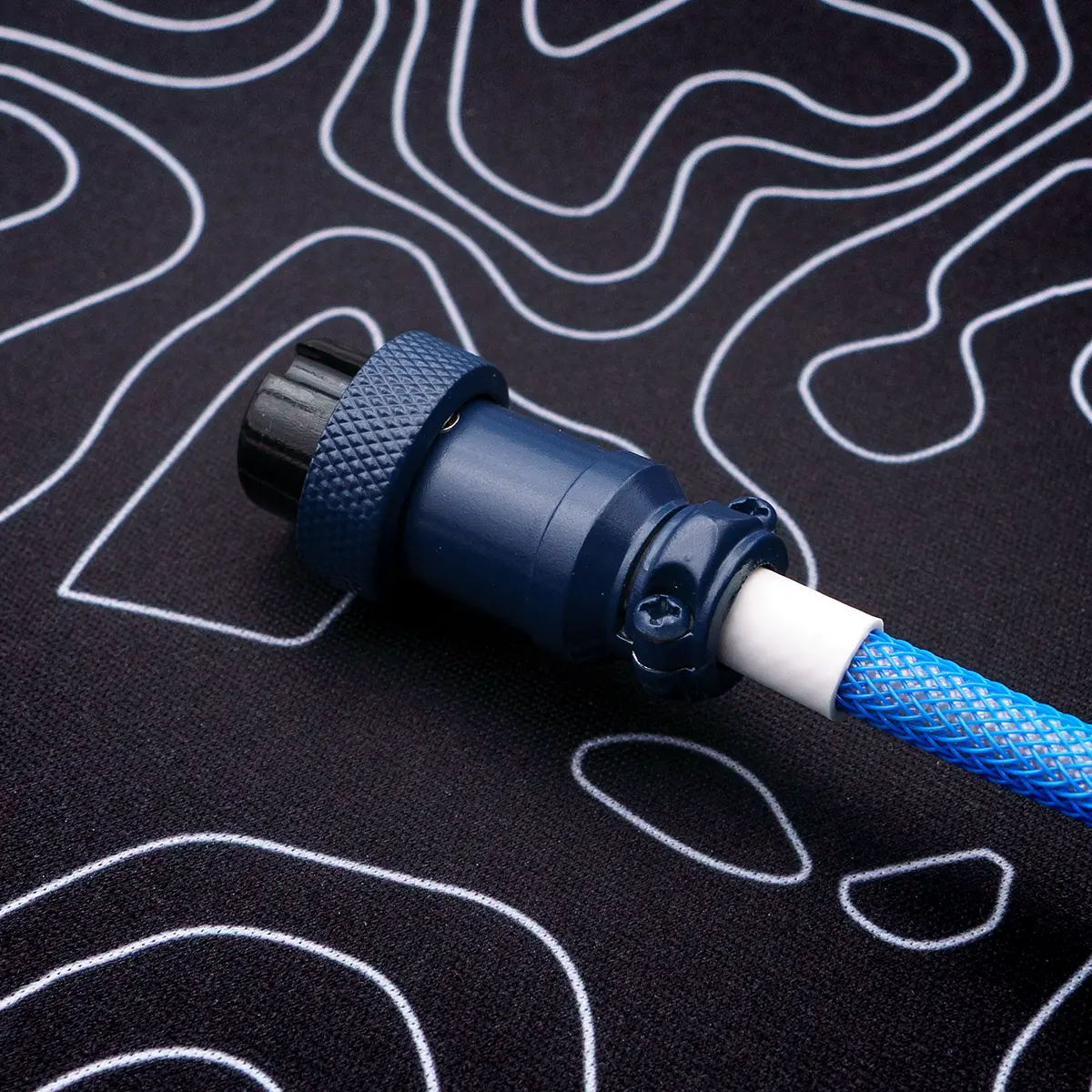 Close-up of a blue braided keyboard cable featuring a CNC metal aviator connector. Ideal for custom setups, showcasing quality craftsmanship and durability.
