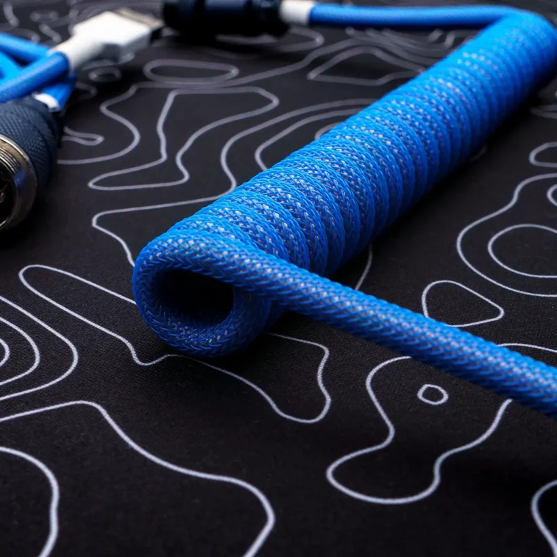 Coiled blue paracord keyboard cable with braided texture, featuring detachable connectors and high-quality CNC metal housing for durability.