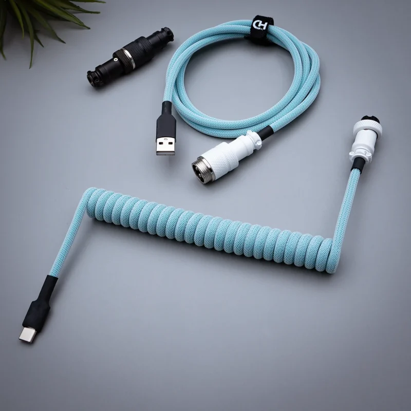 Coiled light blue keyboard cable featuring USB-C and aviator connectors, paracord design, and quality heatshrink for durable performance.