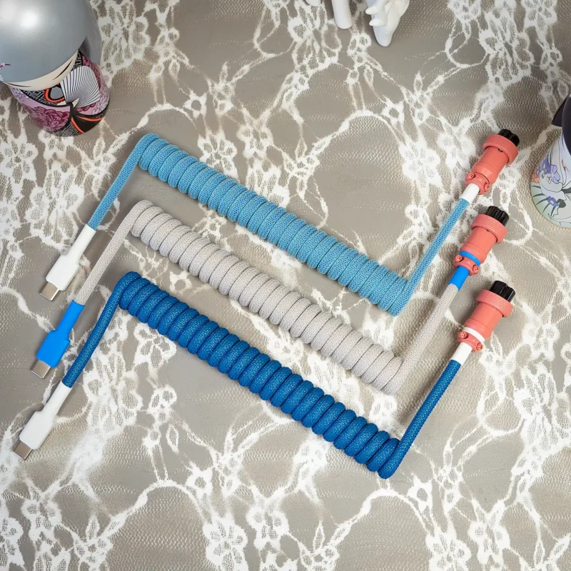 Custom keyboard cables featuring vibrant paracord in blue and gray; includes USB-C and aviator connectors with durable heatshrink and quality braiding.