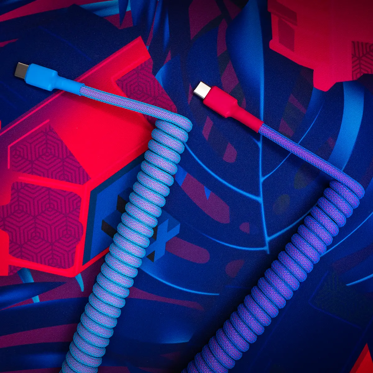 Vibrant GMK Vaporwave keyboard cable featuring a coiled design with blue and pink hues, USB-C connectors, and durable braided paracord for flexibility.