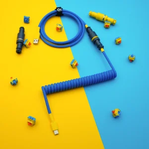Bright blue custom keyboard cable featuring a coiled design, detachable yellow USB-C and aviator connectors, with high-quality paracord braiding and CNC metal housing.