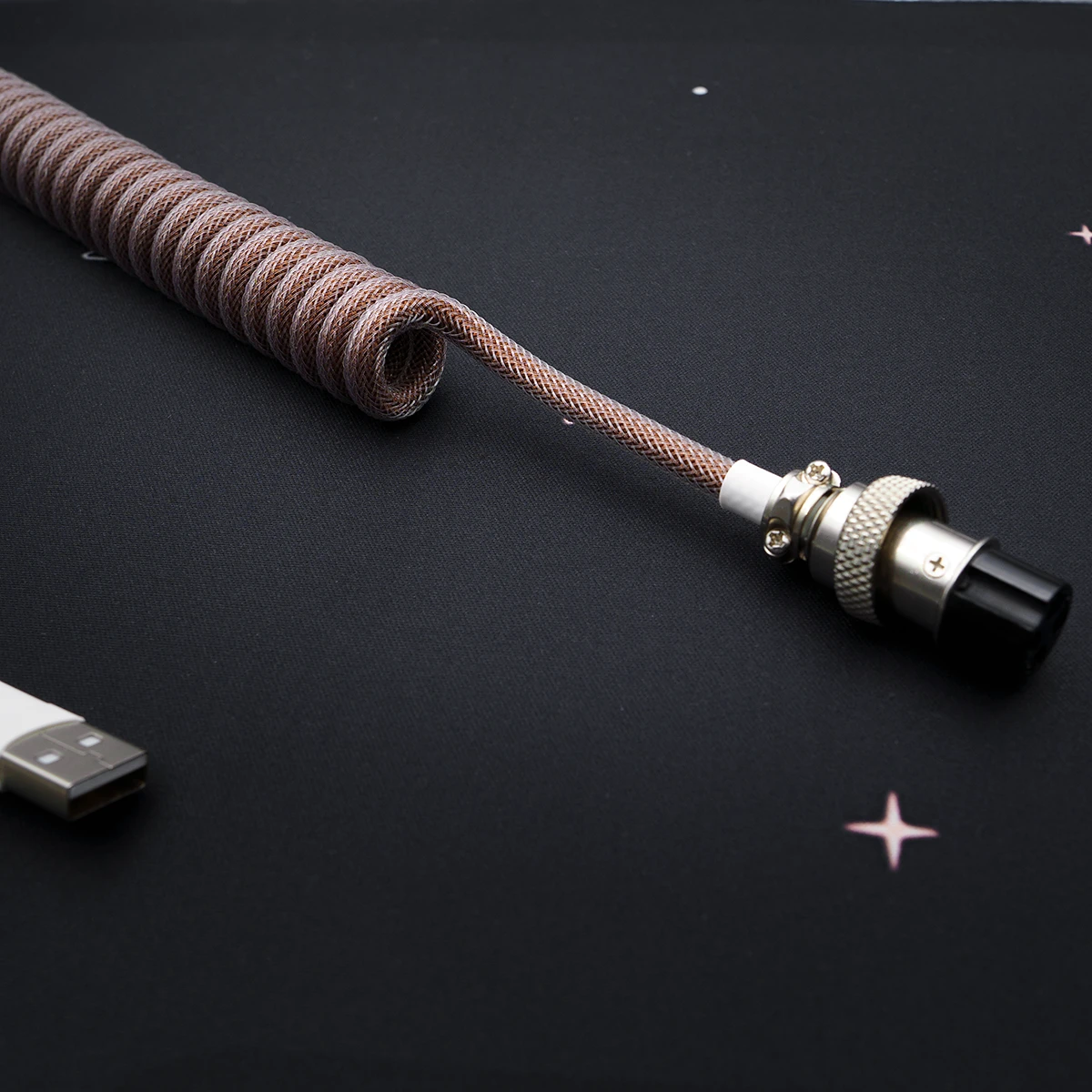 Coiled brown keyboard cable with durable paracord, detachable aviator connector, and quality heatshrink for a stylish and functional setup.