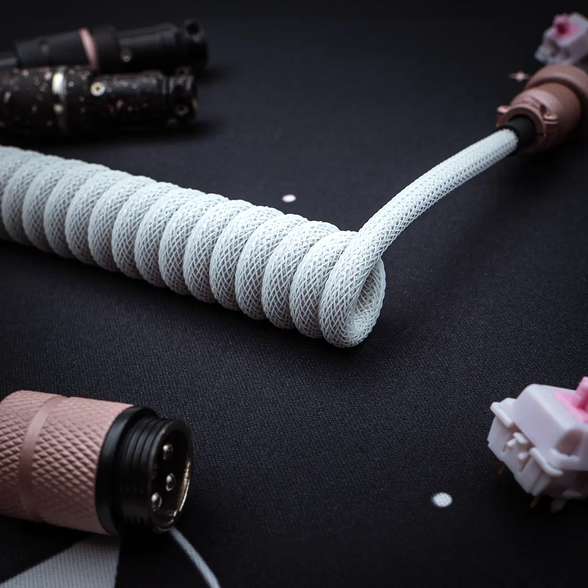 Stylish white coiled keyboard cable with a smooth texture, featuring detachable plugs, quality braiding, and durable connectors for a sleek setup.