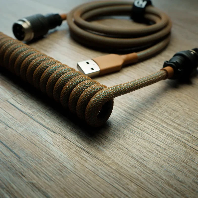 Coiled GMK Copper keyboard cable with USB connector and aviator plug, featuring a sleek brown and green braided design for durability and style.