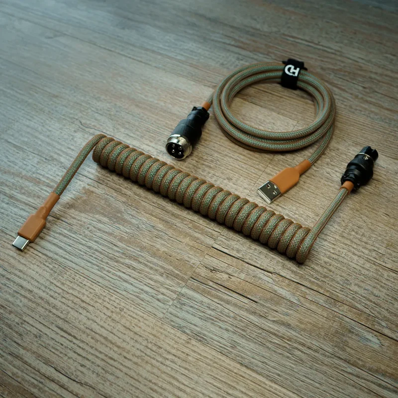 Coiled GMK Copper Keyboard Cable with USB-C and aviator connectors. Features durable paracord, intricate braiding, and high-quality heatshrink for style.