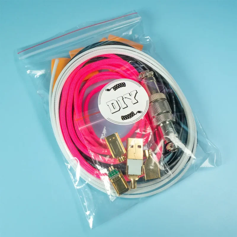 A clear plastic bag contains coiled pink paracord and white techflex, gold connectors, and electronic components labeled "DIY USB kit" on a blue background.