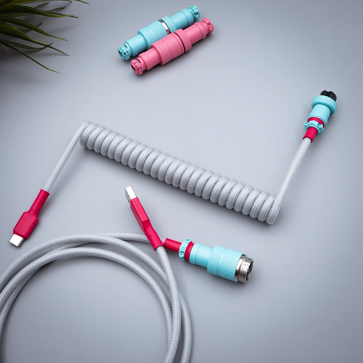 Coiled GMK Modern Dolch keyboard cable featuring USB-C and aviator connectors. Stylish gray techflex with pink and blue accents for a sleek finish.