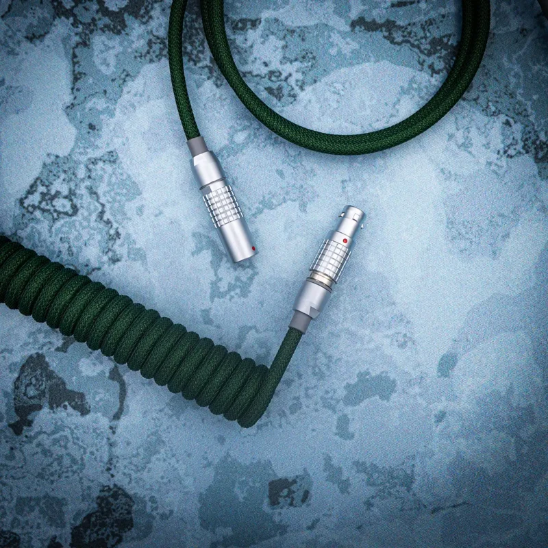 Coiled green paracord keyboard cable featuring detachable metal connectors, ideal for customizable setups; showcases premium braiding and sleek finish.