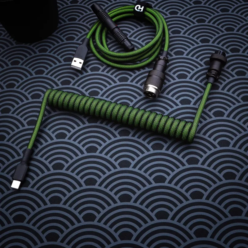Custom green keyboard cable featuring a coiled part and straight section, equipped with USB-C and aviator connectors for versatile compatibility.