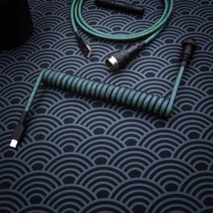 A vibrant green coiled keyboard cable, featuring a USB-C connector with a textured paracord finish and high-quality CNC metal housing.