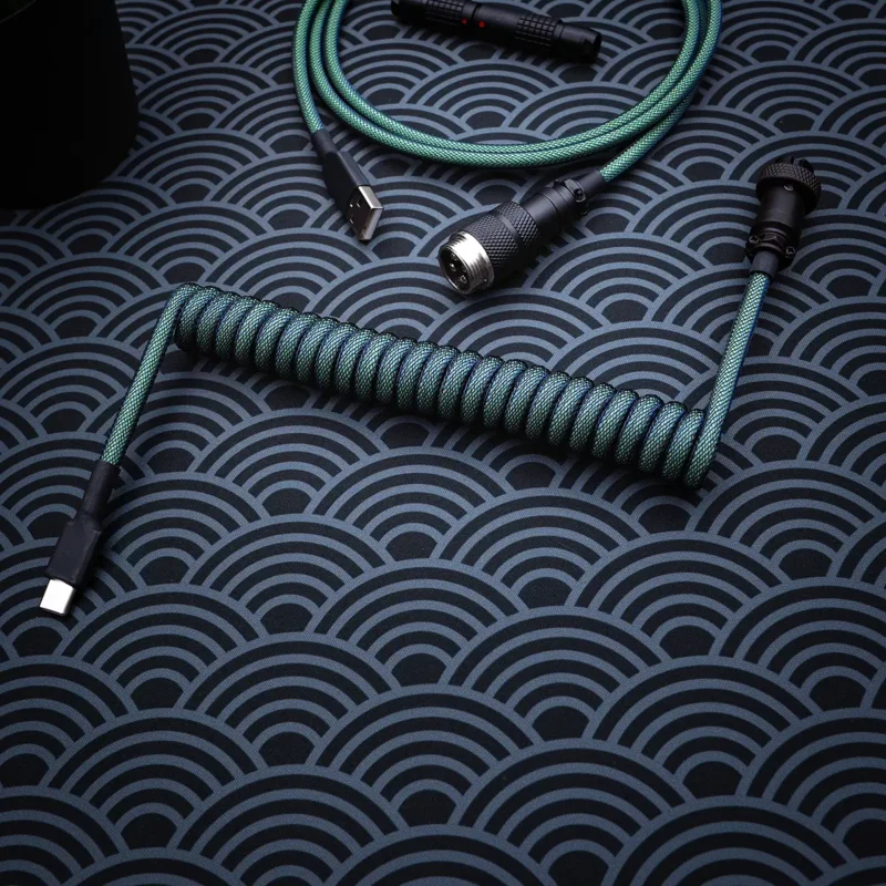 A vibrant green coiled keyboard cable, featuring a USB-C connector with a textured paracord finish and high-quality CNC metal housing.