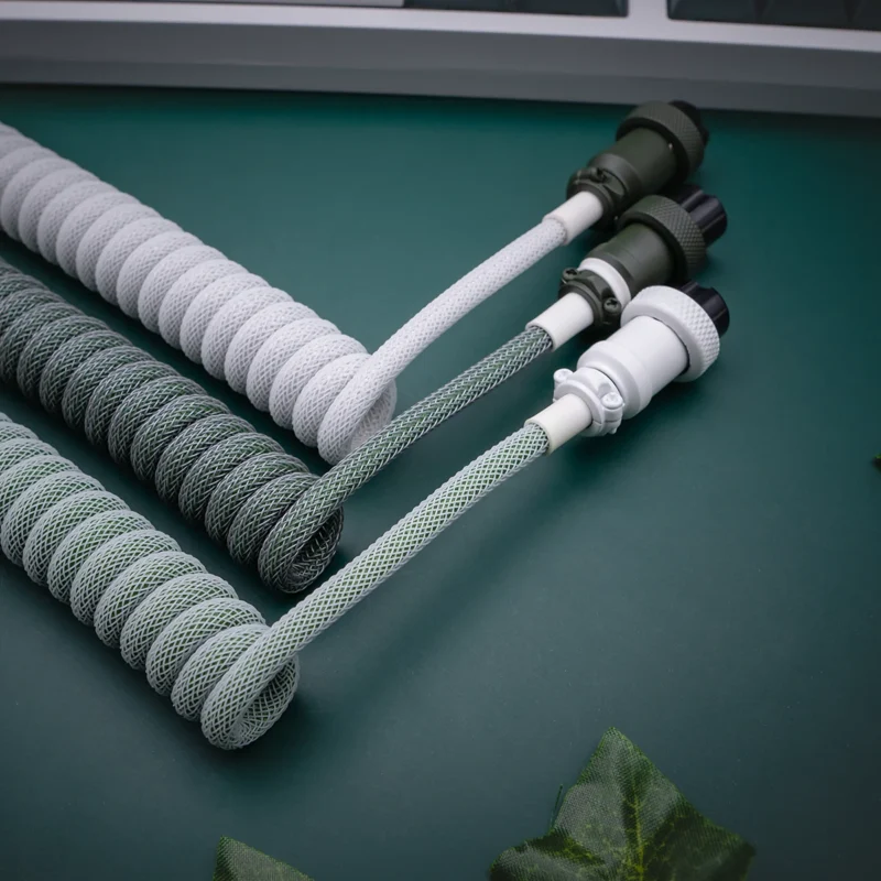 Custom keyboard cables in a botanical theme, featuring coiled designs in gray and green, nylon braiding, and detachable connectors for easy use.