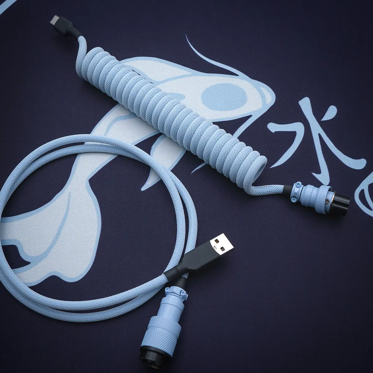 Blue GMK Mizu keyboard cable featuring a coiled design, USB-C connector, detachable aviator plug, and textured paracord finish for durability and style.