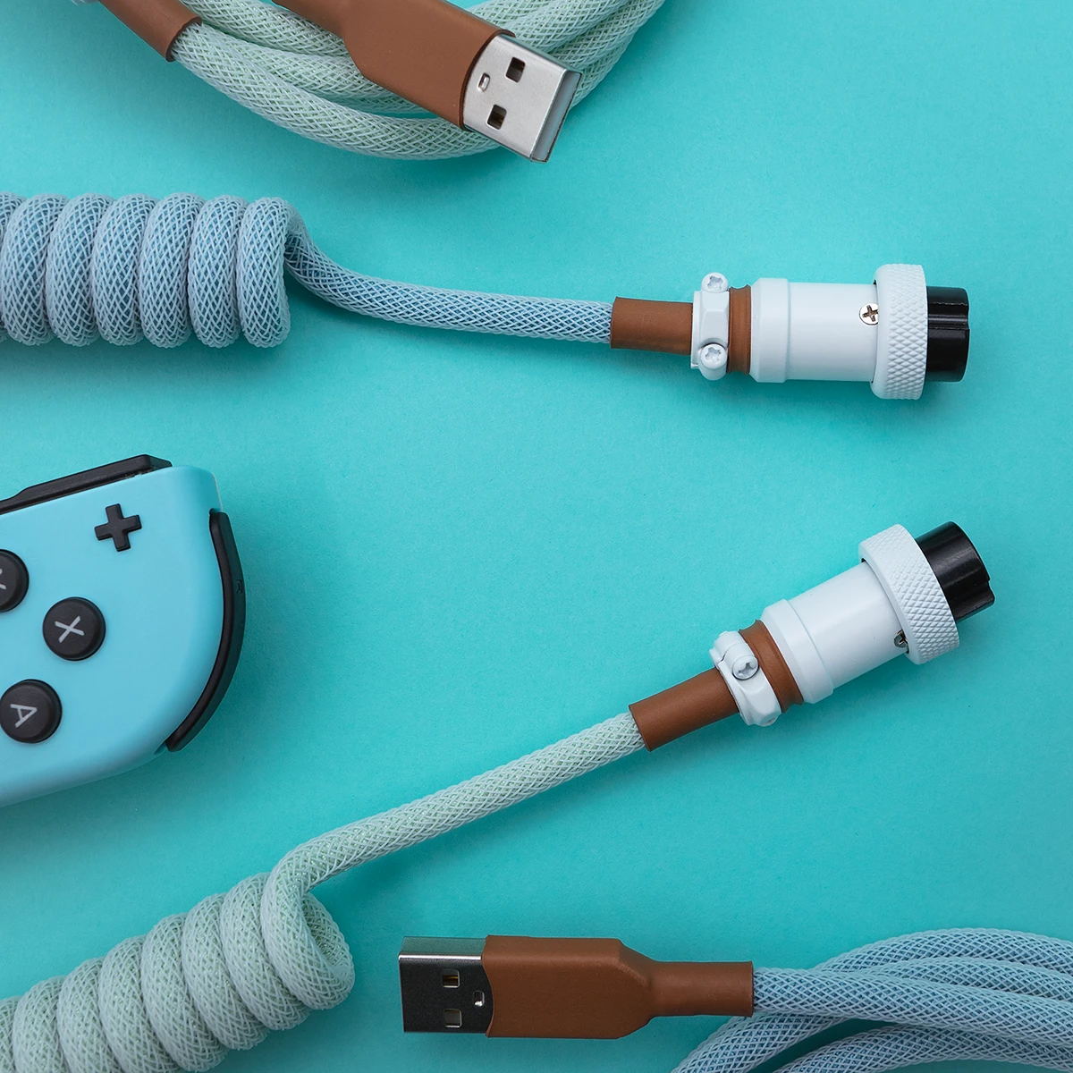 Coiled PBT Islander keyboard cable features a light blue and brown paracord design, USB-C and aviator connectors with durable CNC metal housing, perfect for custom setups.
