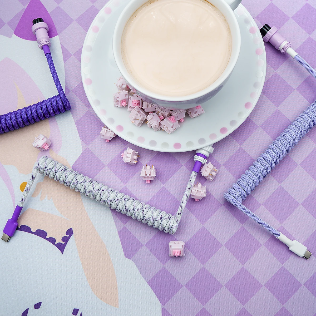 Coiled purple and white keyboard cable with USB-C connectors, showcasing high-quality braiding, heatshrink, and detachable plugs on a pastel background.