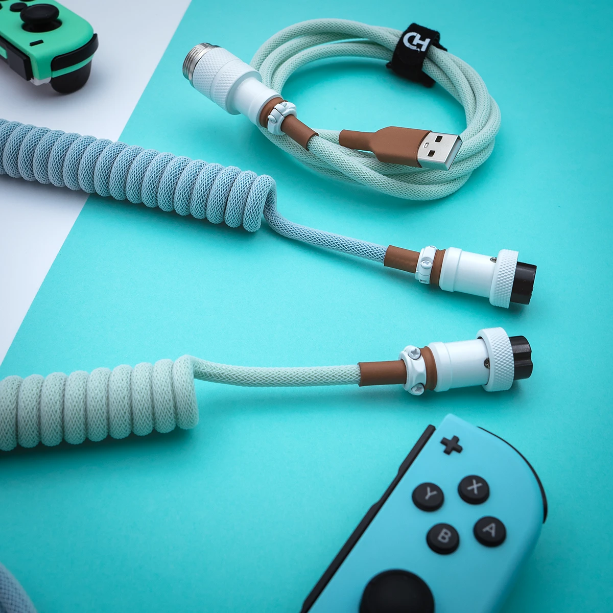 Coiled PBT Islander Keyboard Cable features a textured mint and brown paracord design with USB-C and GX16 connectors for a stylish, durable connection.