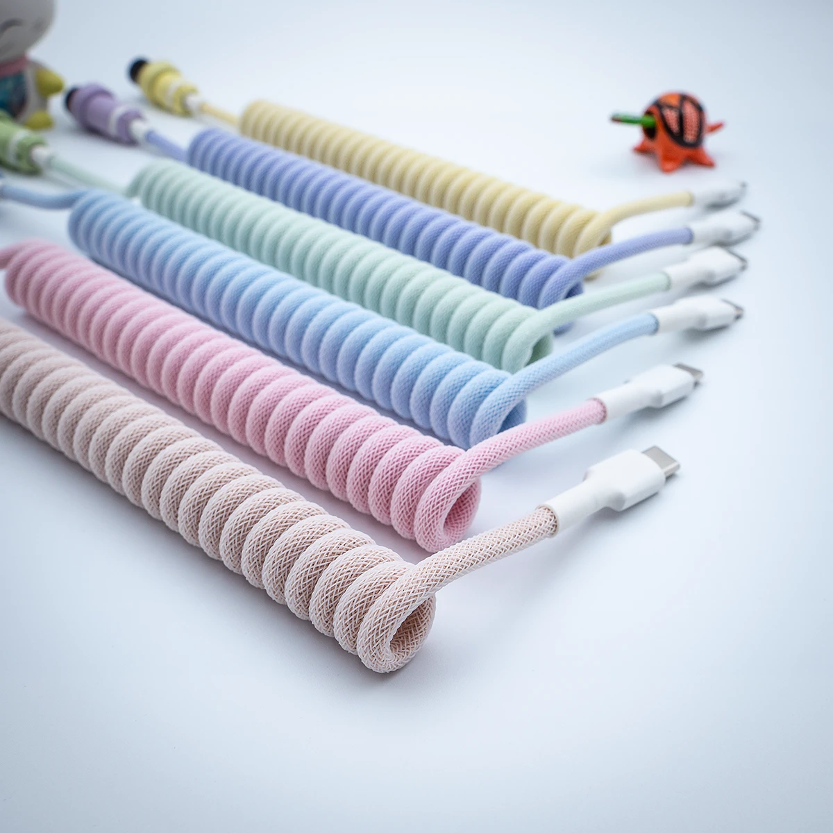 Colorful PBT milkshake keyboard cables with varying coil lengths, featuring durable paracord braiding, and USB-C connectors for stylish customization.