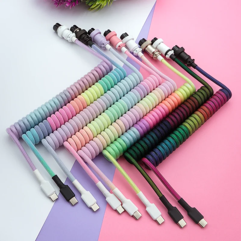 Colorful coiled custom keyboard cables with various lengths and detachable USB-C connectors, featuring braided paracord sheathing for quality and durability.