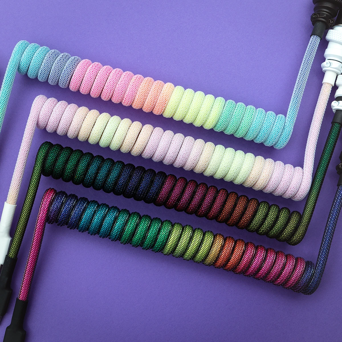 Colorful custom keyboard cables with varying coil lengths and textures, featuring USB-C and aviator connectors. Durable paracord finish enhances style.