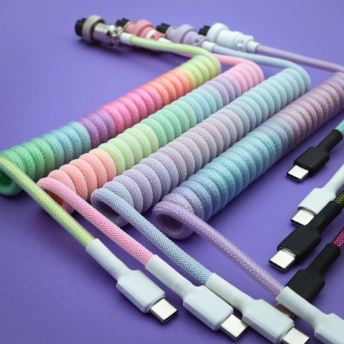 Vibrant rainbow keyboard cables featuring a mix of braided textures, detachable USB-C connectors, and quality heatshrink, perfect for custom setups.