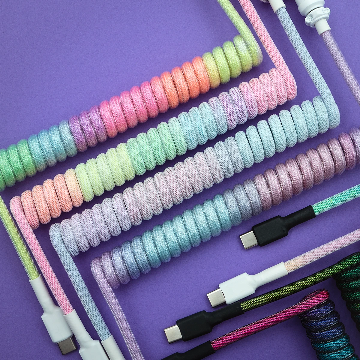 Colorful custom keyboard cables feature various coils and textures, including USB-C connectors and detachable plugs, showcasing vibrant, braided designs.