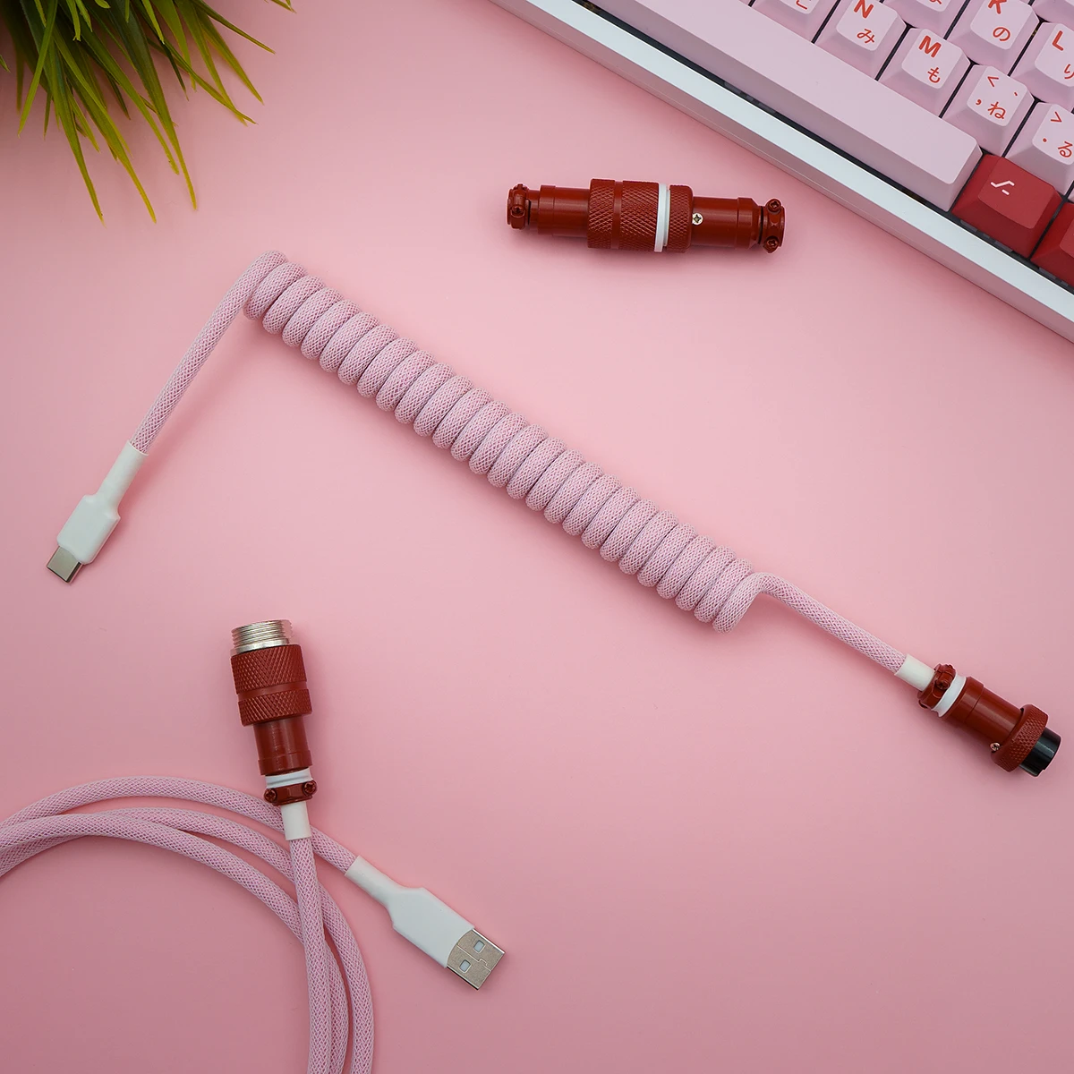 Custom keyboard cable featuring a pink paracord coiled section, USB-C and detachable aviator connectors for flexibility and style. High-quality finish.