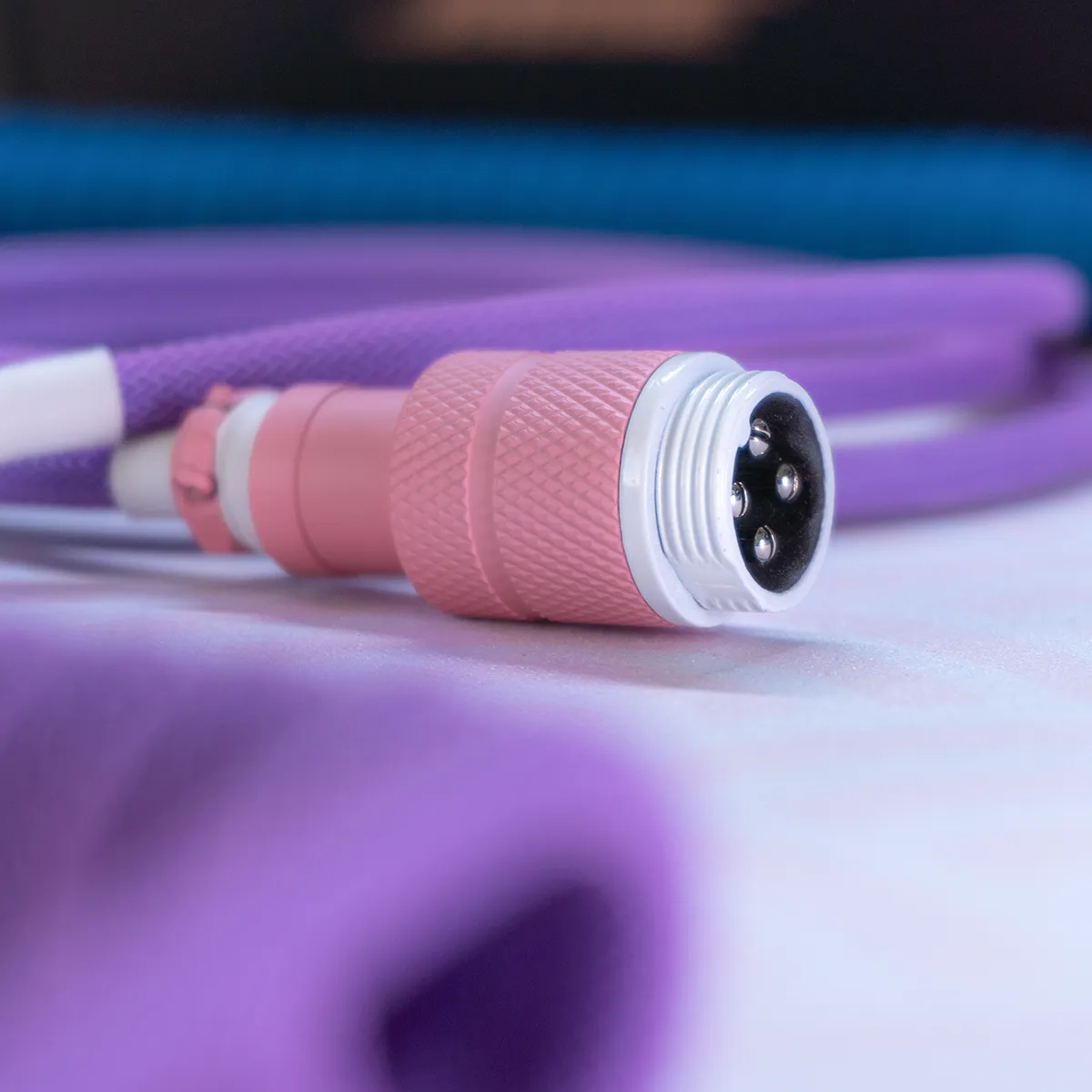 Close-up of the KAM Li'l Dragon Keyboard Cable featuring a textured pink aviator connector, vibrant purple paracord, and durable finish for high-quality custom setups.