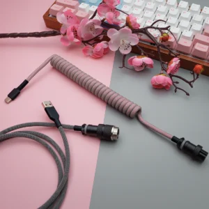 Coiled pink paracord keyboard cable with USB-C and aviator connectors. Features quality braiding and detachable plugs for flexibility and style.