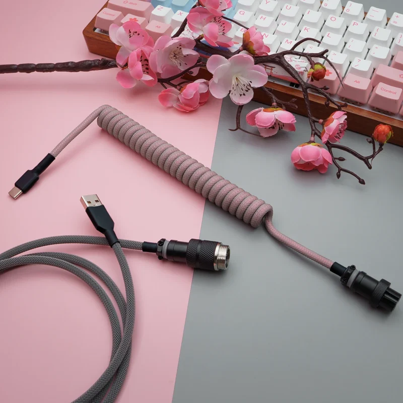 Coiled pink paracord keyboard cable with USB-C and aviator connectors. Features quality braiding and detachable plugs for flexibility and style.