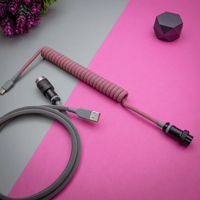 A stylish gray paracord keyboard cable featuring a coiled section and a straight segment, equipped with USB-C and detachable plugs for versatile connectivity.