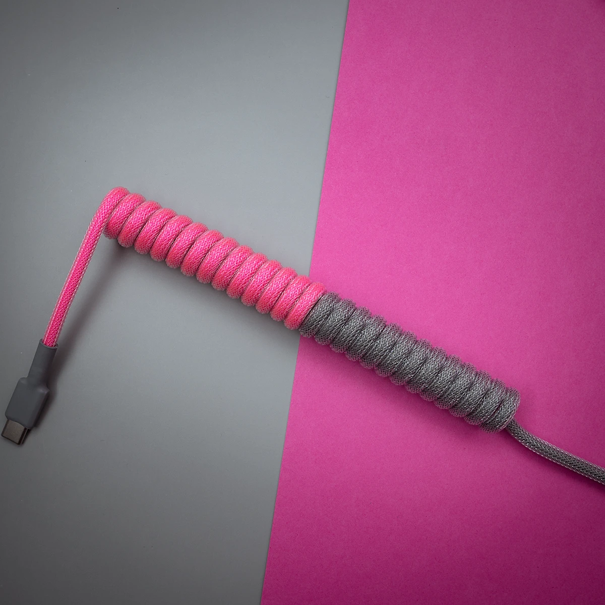 Custom GMK 80082 keyboard cable features a vibrant pink and gray coiled design, USB-C connector, high-quality braiding, and durable heatshrink for maximum flexibility.