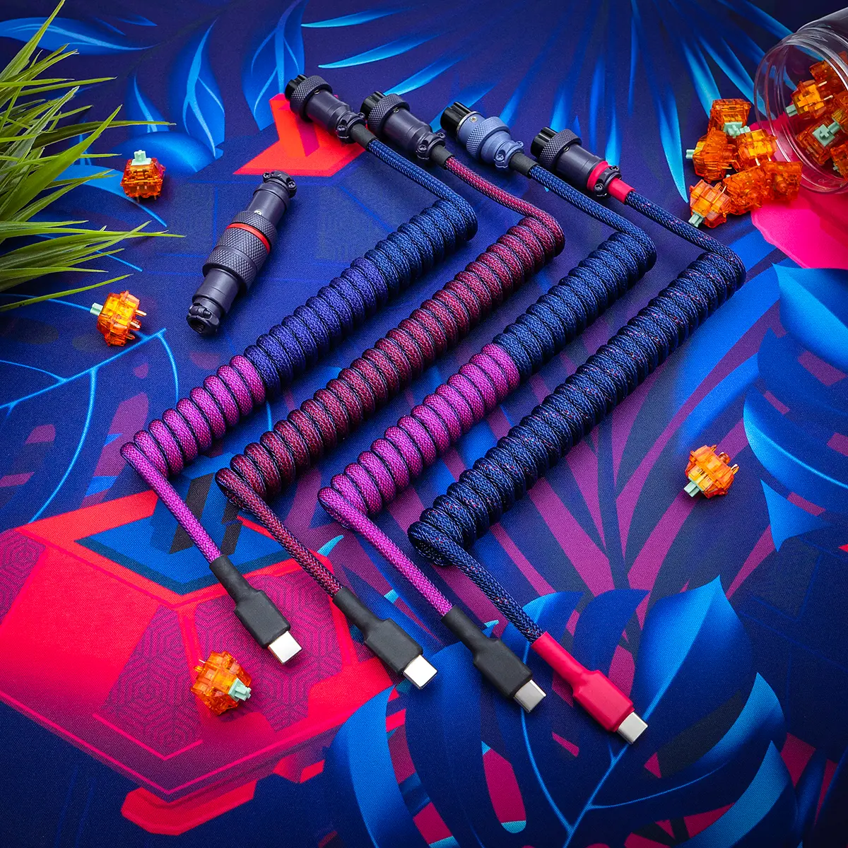 Coiled keyboard cables in vibrant colors feature USB-C and micro-USB detachable connectors. The durable paracord texture enhances the aesthetic appeal.