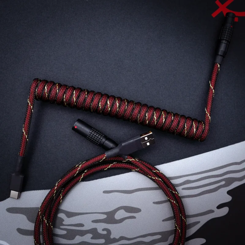 Coiled GMK Red Samurai Keyboard Cable with textured red and black paracord. Features USB-C, detachable aviator connectors, and high-quality braiding.