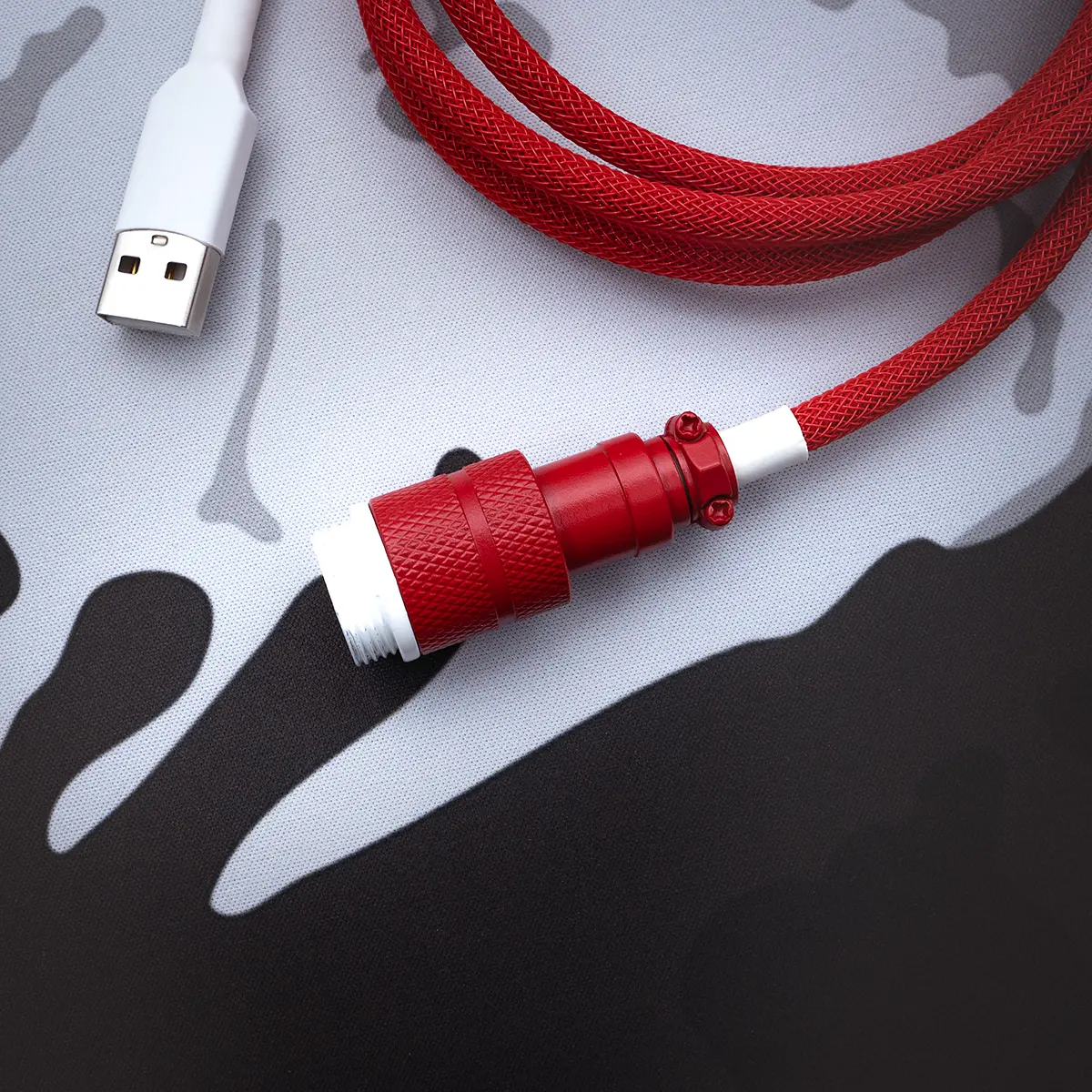 A vibrant red braided keyboard cable features a sturdy USB-C connector and a sleek detachable aviator plug, ensuring durability and style for your setup.