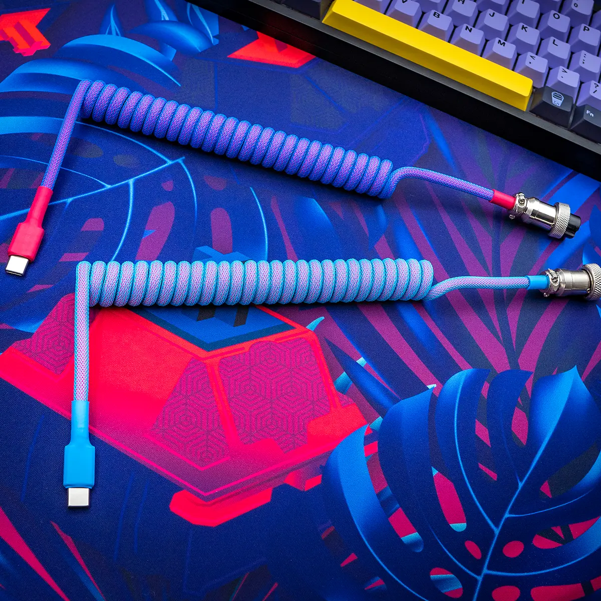 Coiled GMK Vaporwave keyboard cable featuring USB-C connectors, vibrant blue and pink paracord, detachable aviator plug, and quality braiding.