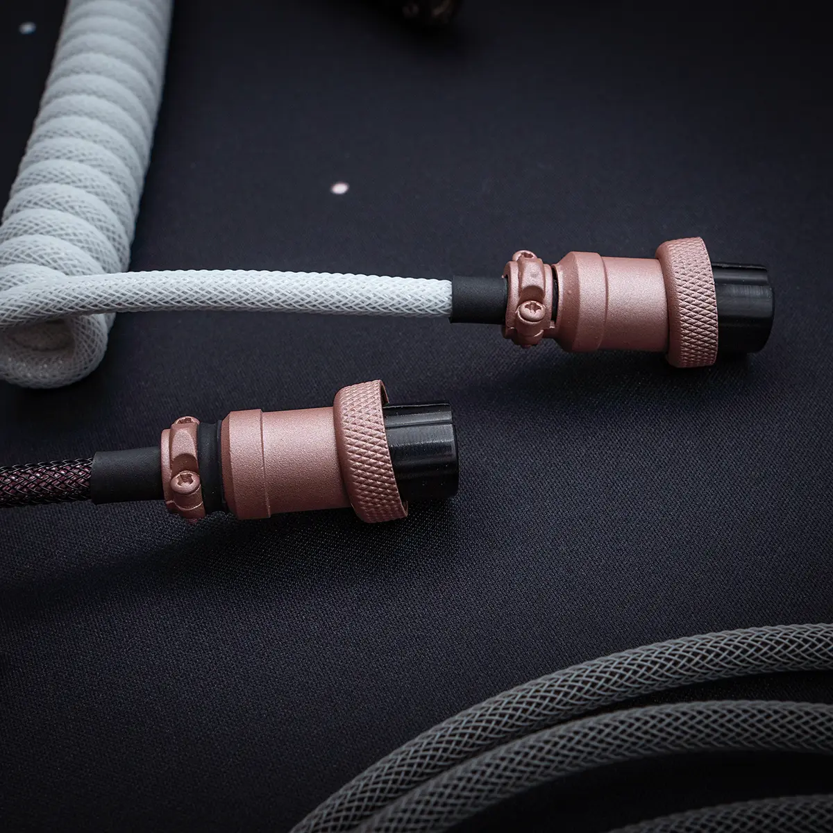 Coiled GMK Olivia keyboard cable features a sleek paracord finish, dual detachable plugs (USB-C and aviator), and premium CNC metal housing for durability.