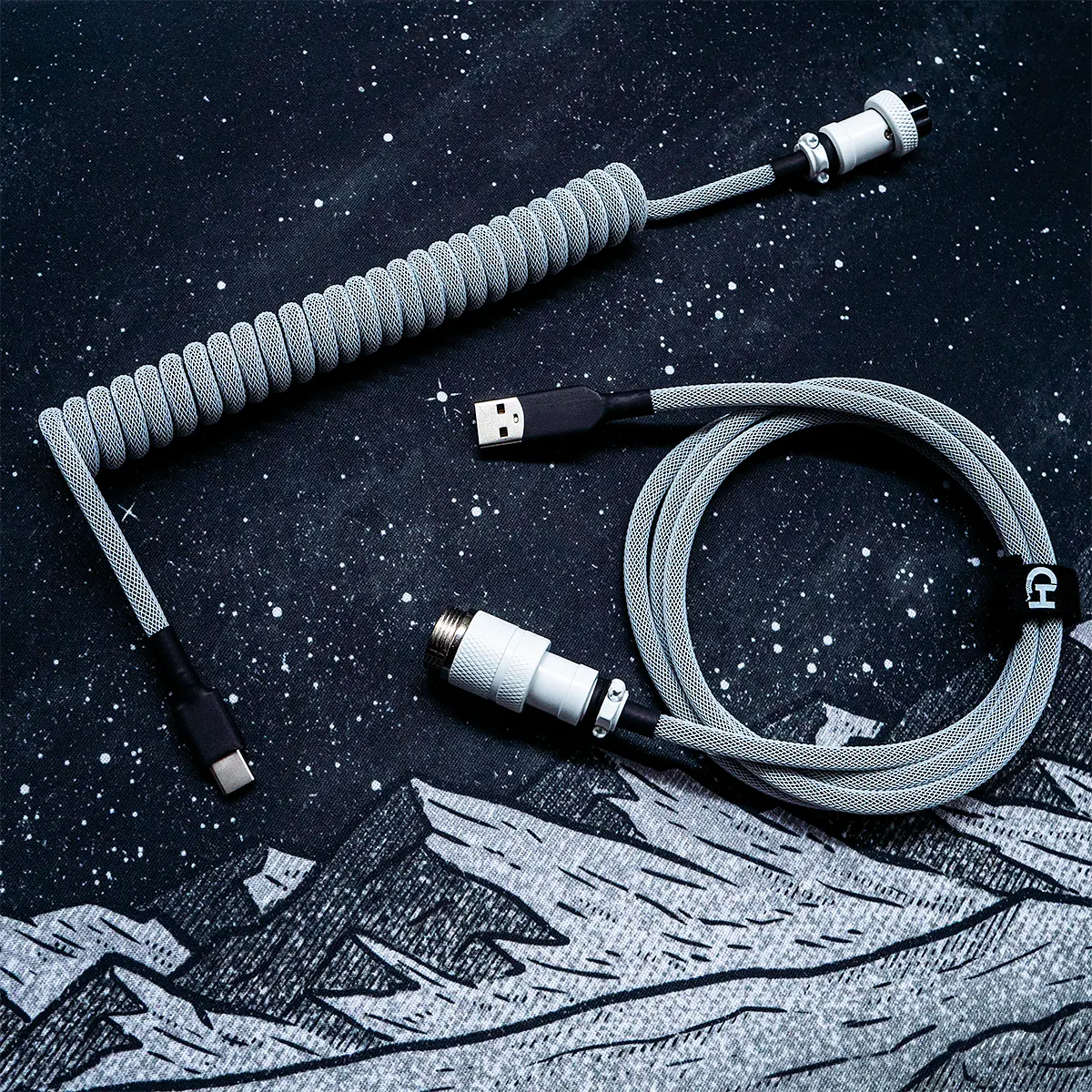 A coiled GMK Classic BoW keyboard cable featuring a gray paracord, detachable USB-C connector, and CNC metal aviator housing for premium quality and style.